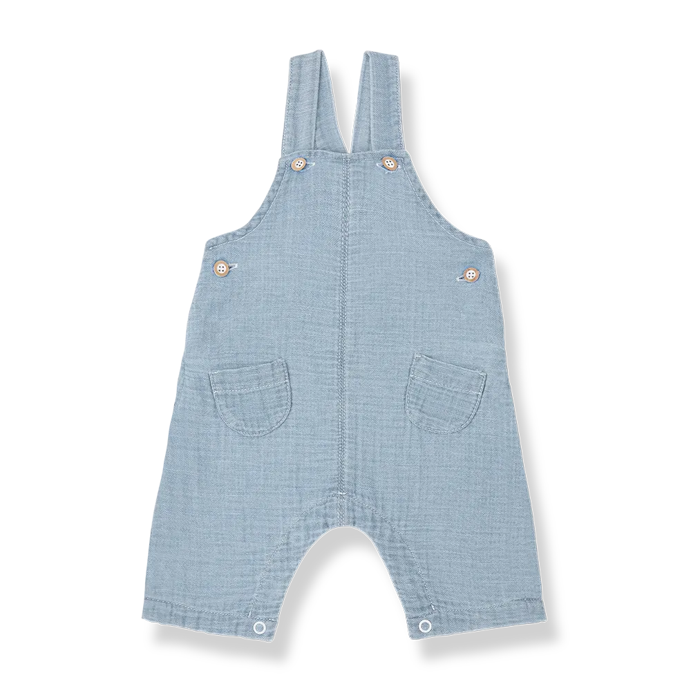 blaue Musselin-Jeanslatzhose für Babys aus 100% Baumwolle mit zwei klassischen Hosenträgern, Knopfverschluss an der Seite und im Windelbereich und mit zwei kleinen aufgesetzten Taschen, Produktbild, Ansicht von vorne