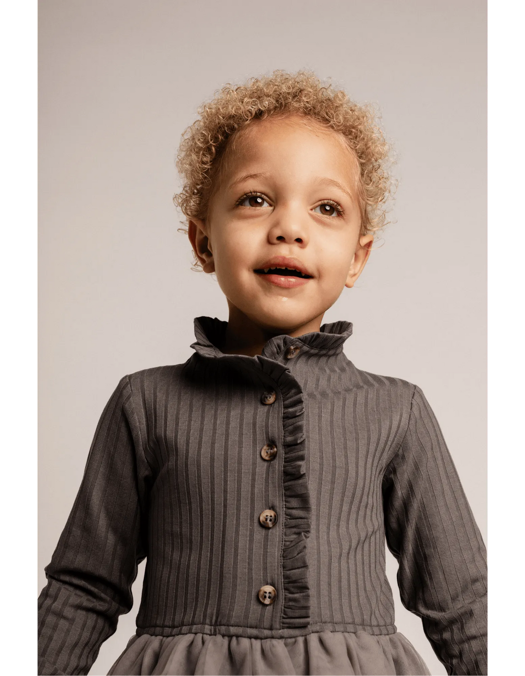 Baje Marly grey steel getragen von einem Mädchen mit Fokus auf den oberen Teil des Kleides und hier dem mit Rüschen besetzen Stehkragen und der Knopfleiste