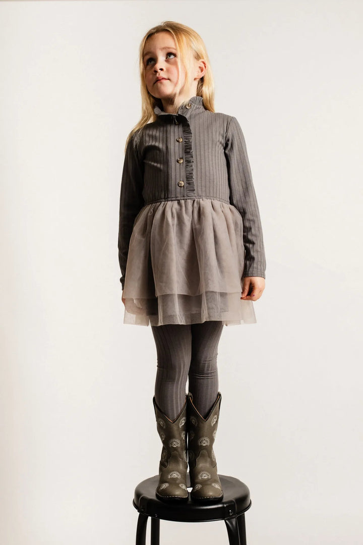 Baje Marly grey steel getragen von einem Mädchen stehend auf einem Hocker vor weißem Hintergrund