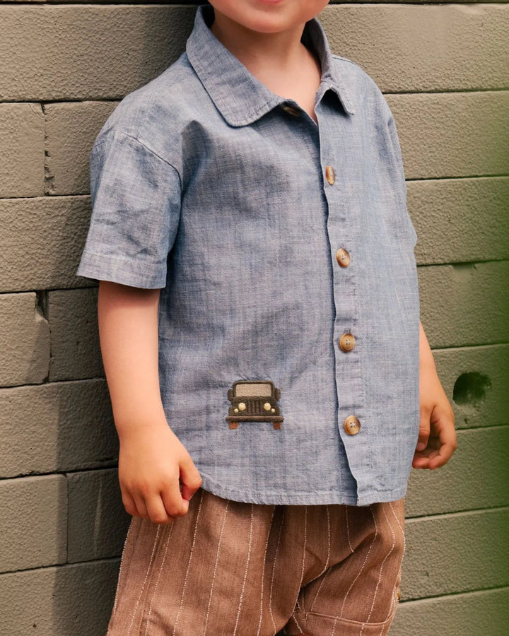 Donsje Ludon Shirt Jeep sky blue getragen von einem männlichen Kleinkind stehend vor einer Mauer, Fokus auf dem Hemd, Ansicht von vorne