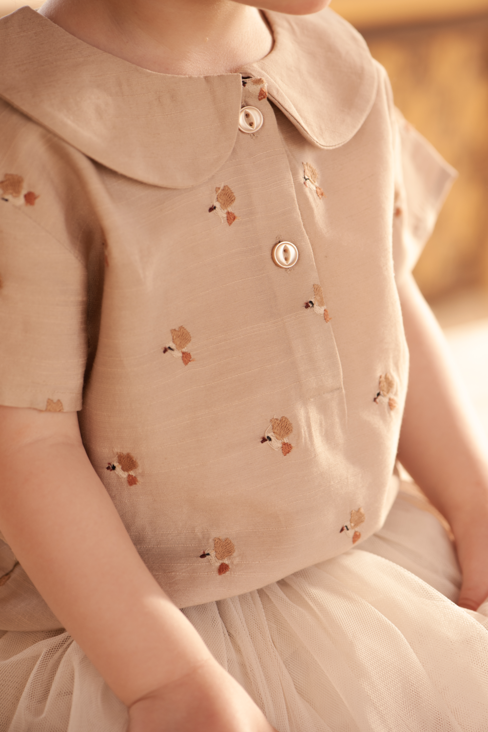 Donsje Nesa Blouse Hummingbirds soft taupe getragen von einem Mädchen, Nahaufnahme mit Blick auf die kleinen Kolibris