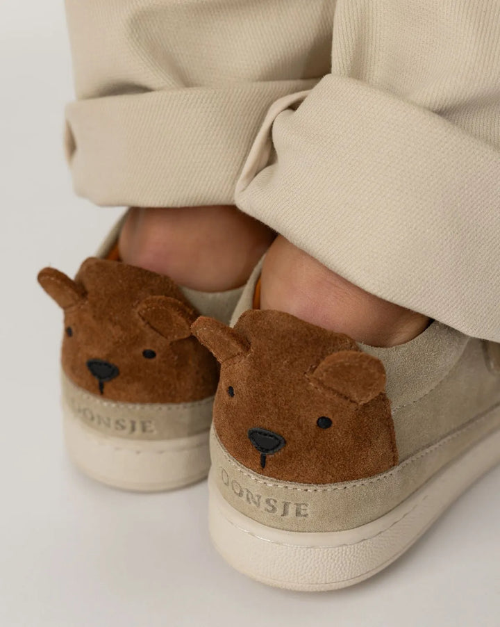 Donsje Rinou Sneakers Bear taupe suede getragen von einem Kind, Fokus auf den beiden Bärengesichtern an der Ferse