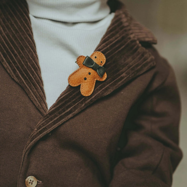 Donsje_Wonda_Hairclip_Gingerbread_toast_grain_leather angesteckt am Revers einer Kinderjacke. 