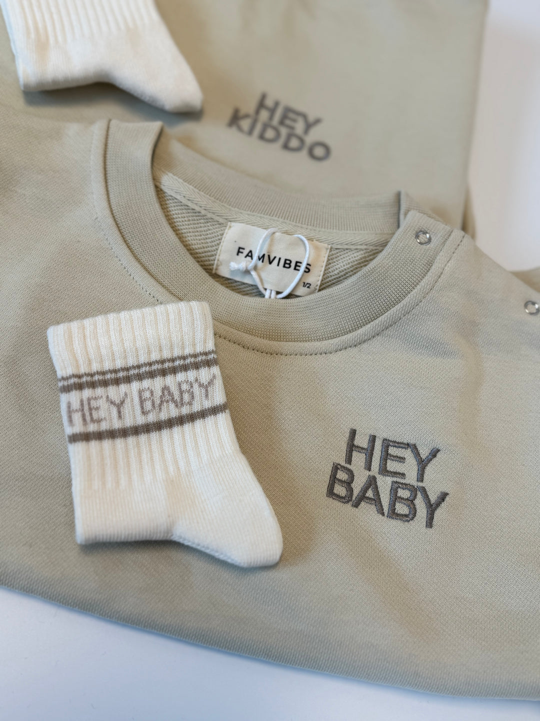 weiße Socken für Babys aus Baumwolle mit taupefarbenem Schriftzug Hey Baby
