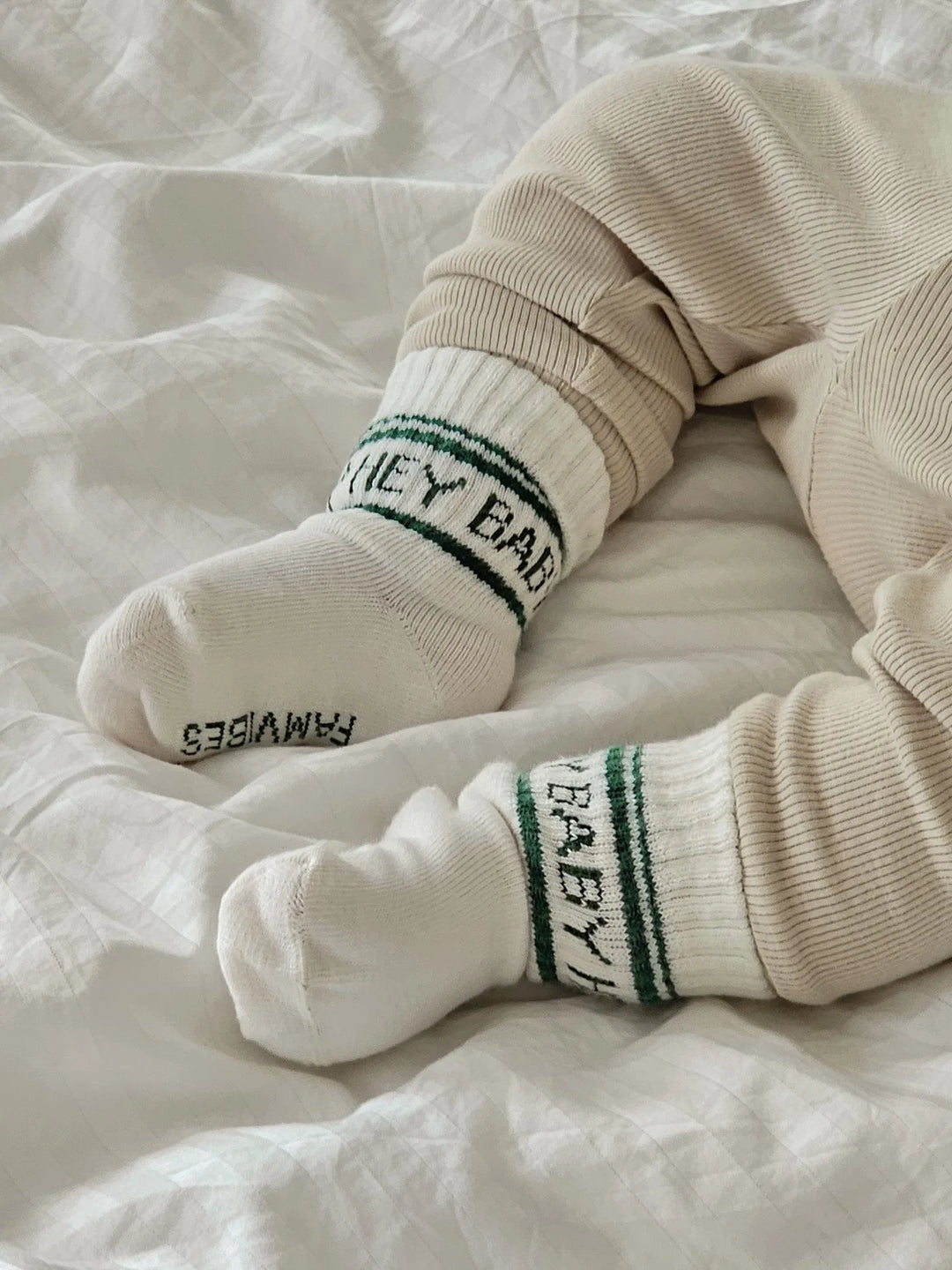 cremeweiße Socken aus Baumwolle mit grünem Schriftzug Hey Baby