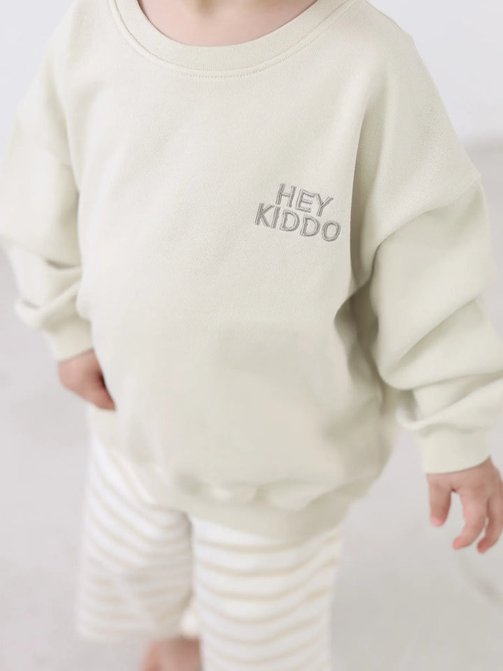 beigefarbenes Sweatshirt für Kinder aus Baumwolle mit taupefarbenem Schriftzug Hey Kiddo