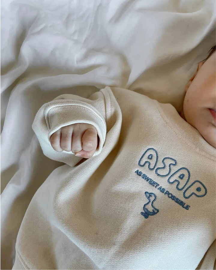cremefarbener Sweater für Babys aus Baumwolle mit aufgestickter Ente und Schriftzug ASAP in hellblau