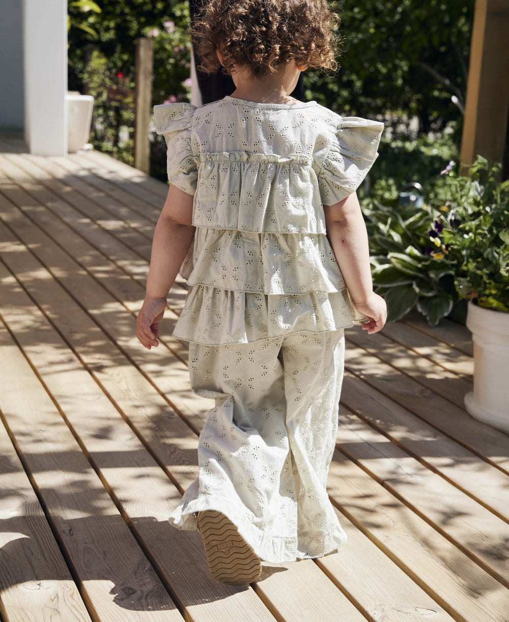 Fliink Harper Top aqua gray getragen von einem Mädchen, kombiniert mit der Harper Rüschen Hose, Ansicht der Rückseite