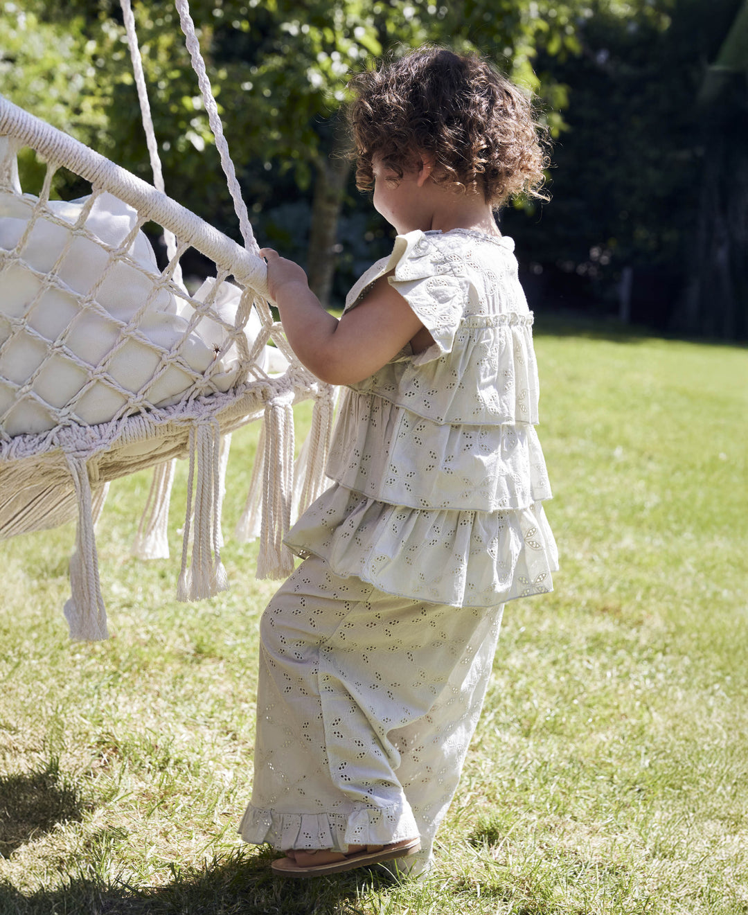 Fliink Harper Top aqua gray getragen von einem Mädchen im Garten, kombiniert mit der Harper Rüschen Hose, Ansicht von der Seite