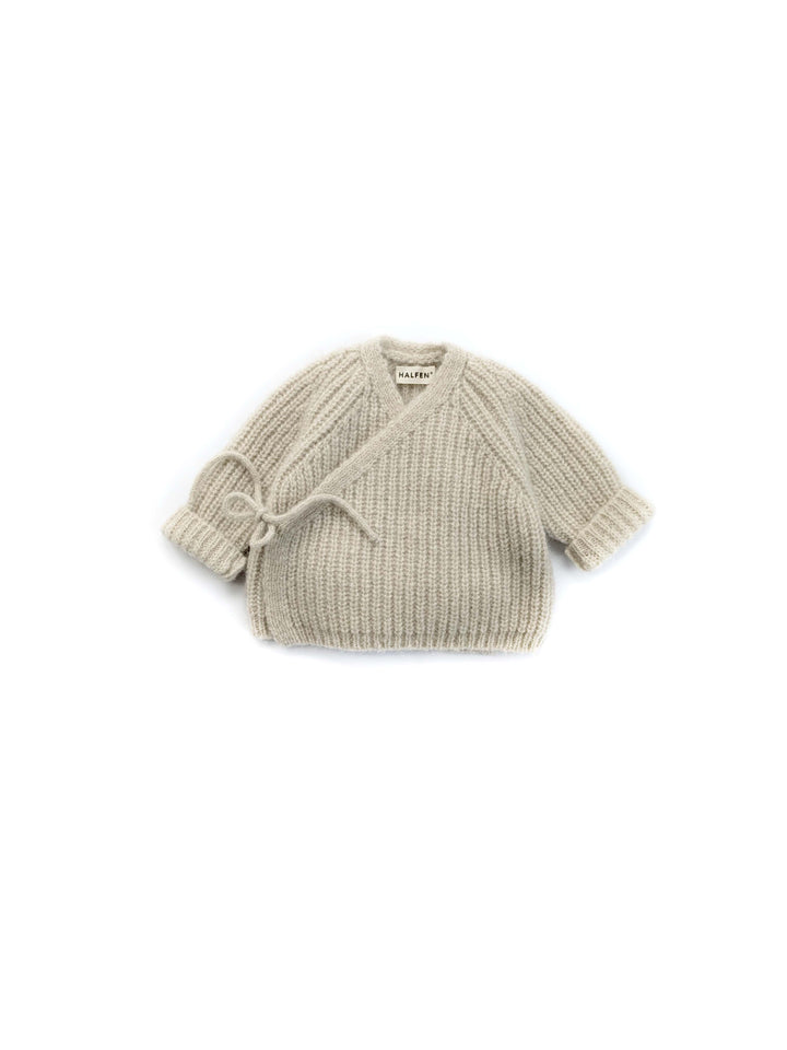 Grob gestrickte, beigefarbene Jacke zum Wickeln mit Bindeband für Babys aus Merinowolle, Alpaka und Seide. V-Ausschnitt und lange Ärmel. Produktbild, Ansicht von vorne. 