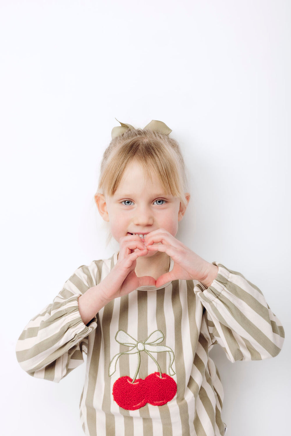Hust & Claire HCSicilia quartz getragen von einem Mädchen vor weißem Hintergrund, Fokus auf Kirsche 