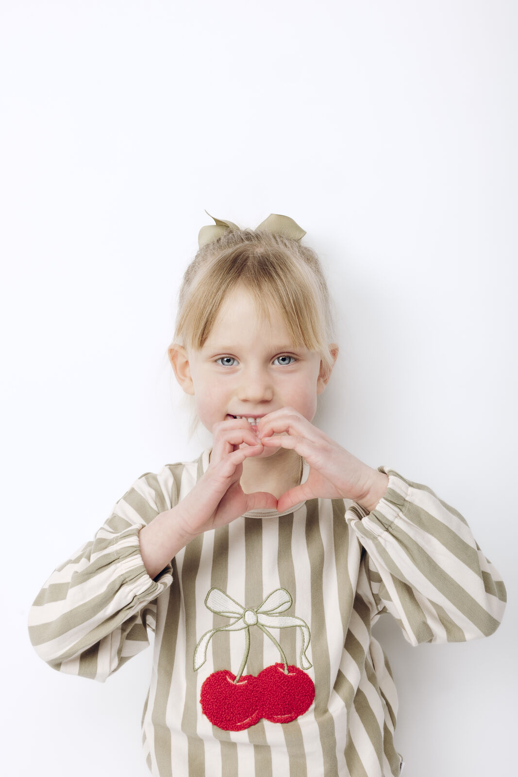 Hust & Claire HCSicilia quartz getragen von einem Mädchen vor weißem Hintergrund, Fokus auf Kirsche 