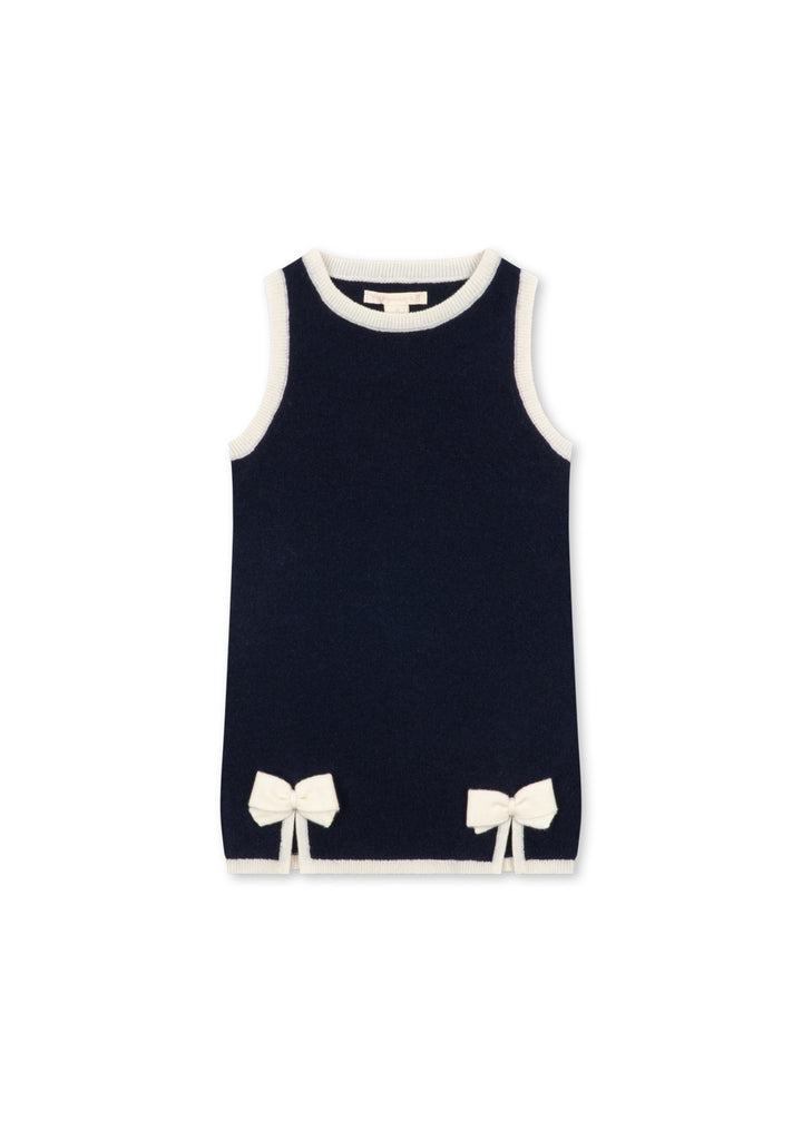 Dunkelblaues, ärmelloses Kleid für Mädchen aus Wolle mit kontrastierenden, weißen Nähten an den Säumen sowie weißen Schleifen oberhalb des unteren Saums. Produktbild, Ansicht von vorne. 
