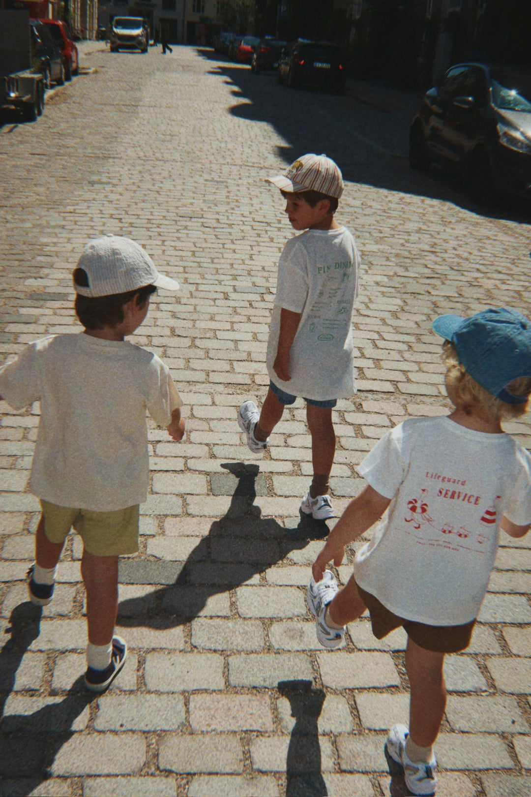 Konges Sloejd Era Tee OCS off white/lifeguard service getragen von einem Jungen auf der Straße, Ansicht der Rückseite