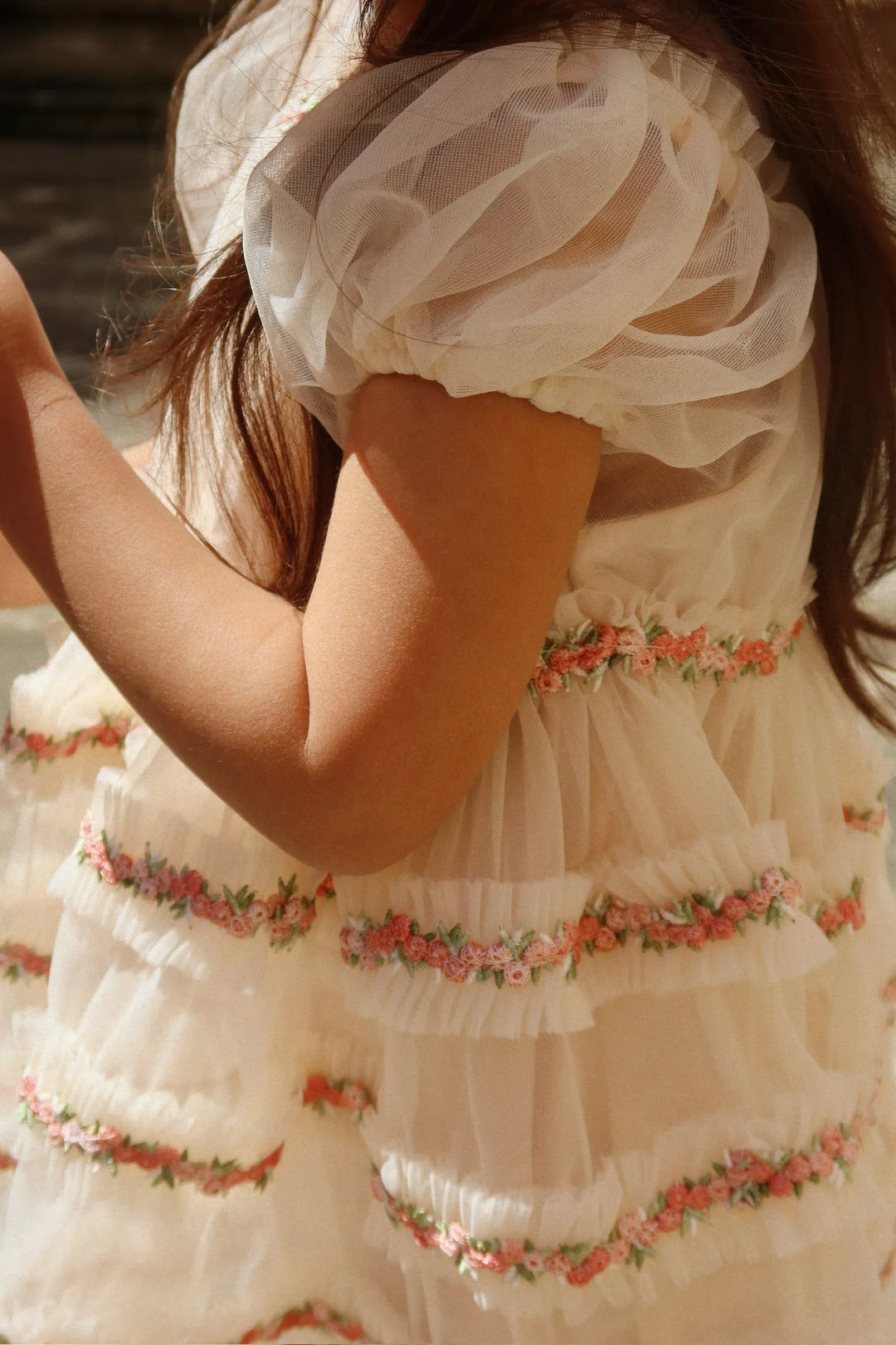 Konges Sloejd Joelle Dress buttercream getragen von einem Mädchen mit Blick auf die fein gestickte florale Spitze und die zarten Puffärmel