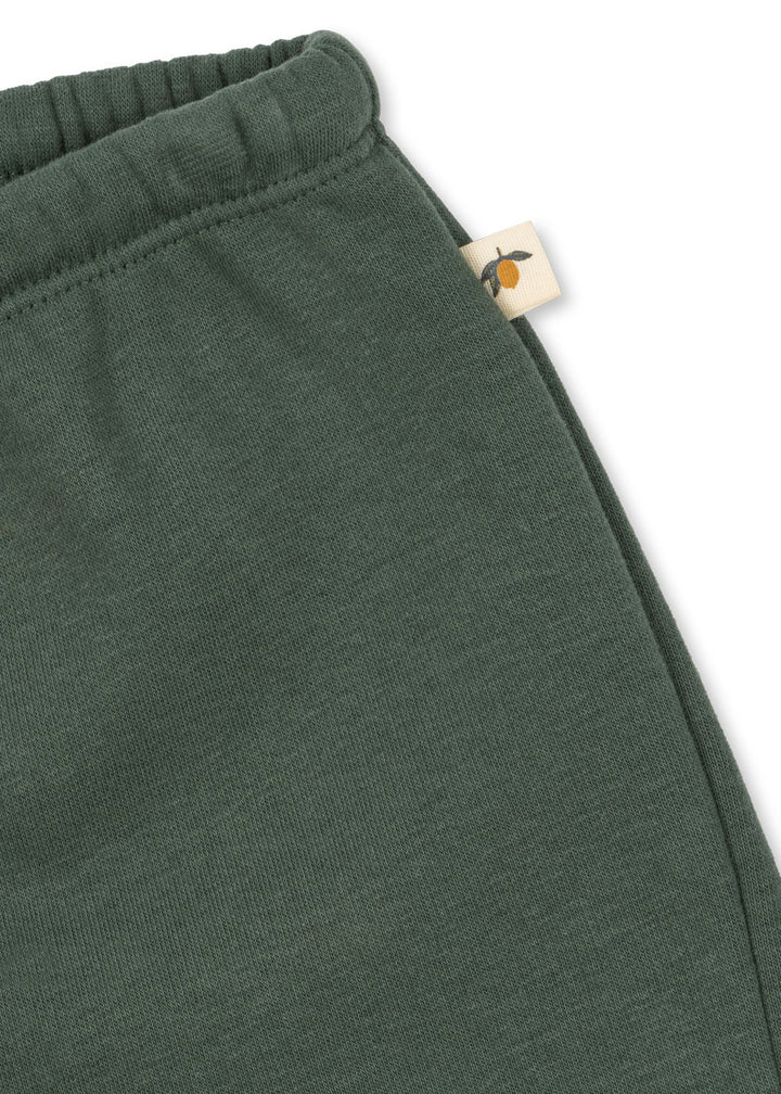 Konges Sloejd Lou Sweat Shorts OCS cilantro Detailansicht Gummibund und kleines Flaggenetikett mit ikonischer Zitrone