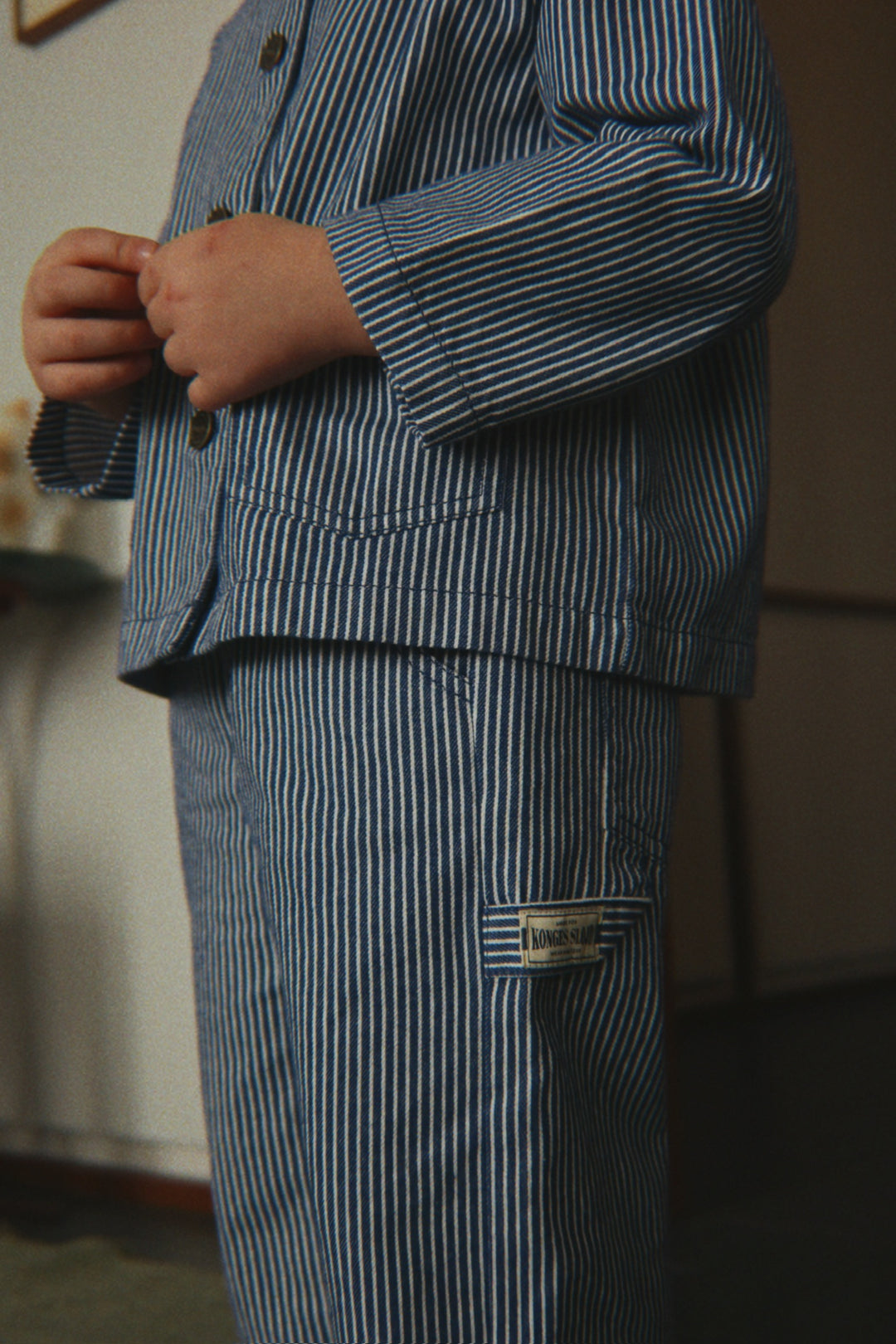 Konges Sloejd Luc Pants GOTS blue stripe getragen von einem Kind, Detailansicht Hammerschlaufe. 