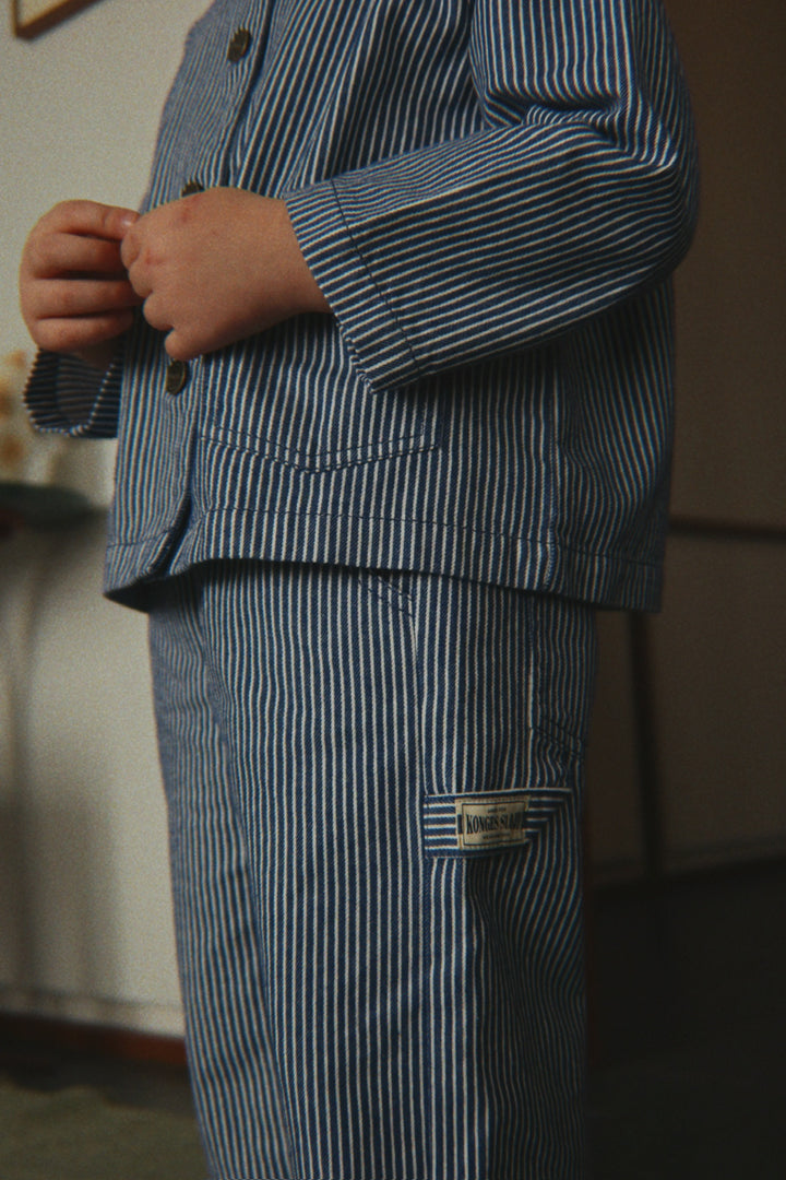 Konges Sloejd Luc Pants GOTS blue stripe getragen von einem Kind, Detailansicht Hammerschlaufe. 