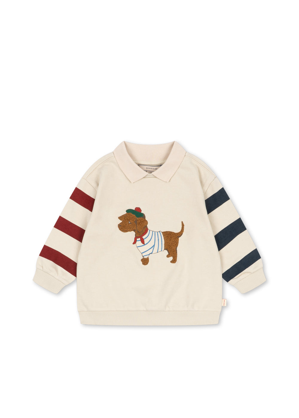 cremefarbenes Sweatshirt mit Polokragen für Kinder aus Bio-Baumwolle mit aufgenähtem Dackel aus plüschigem Frottee, roten und blauen Blockstreifen an den Ärmeln und gerippten Bündchen am Saum und an den Ärmeln. Produktbild, Ansicht von vorne. 