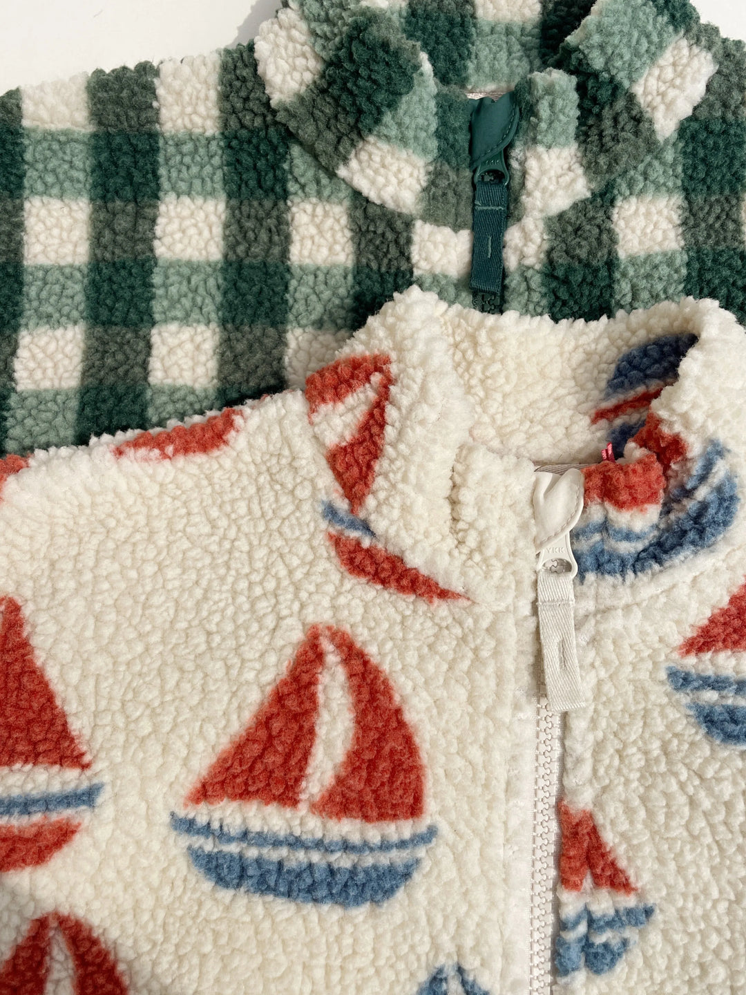 Fleecejacke Jody von Konges Sloejd Farbe ahoy Nahaufnahme Kragen liegend auf anderer, grün karierter Fleecejacke