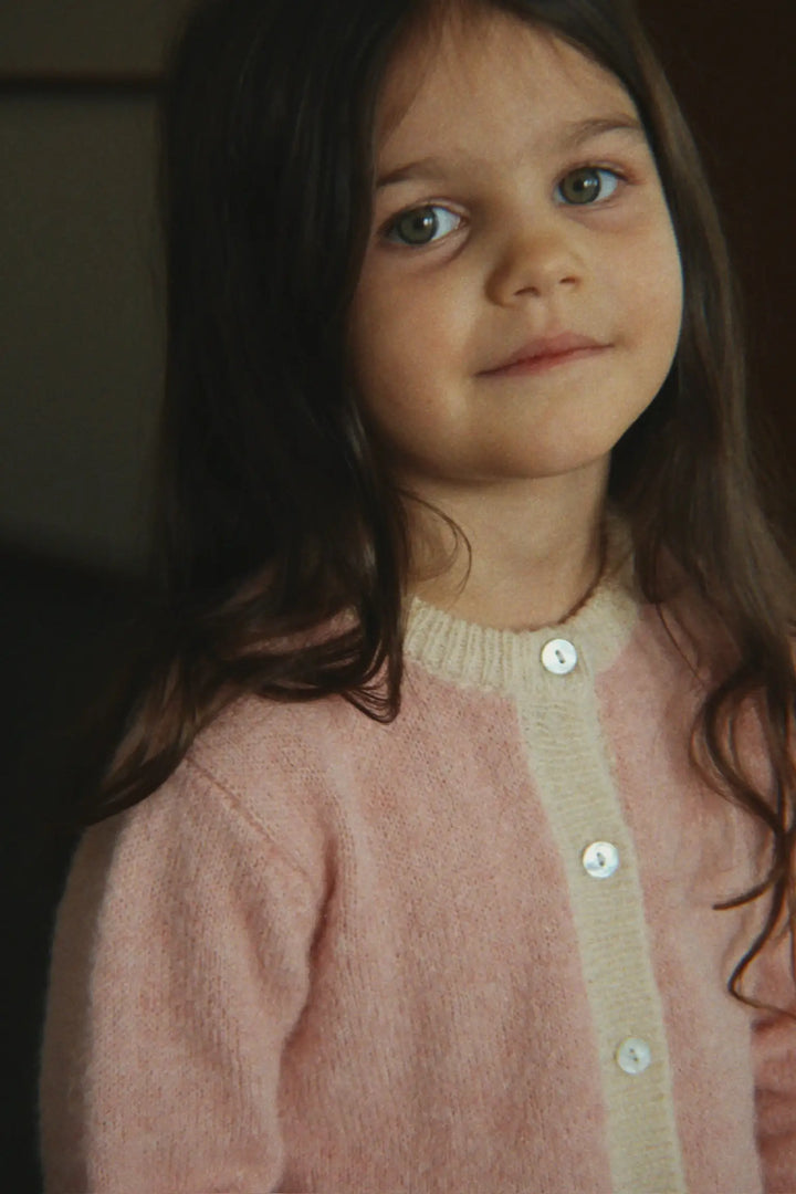 Konges Slojd Kitty Cardigan silver pink getragen von einem Mädchen mit Fokus auf die obere Hälfte des Cardigans mit Blick auf die Knopfleiste aus Perlmutt.