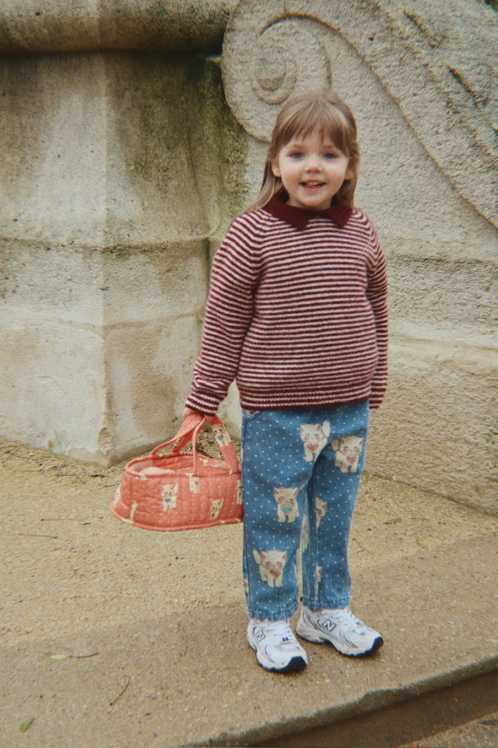 Konges Slojd Magot Frill Pants GOTS ciao miao getragen von einem kleinen Mädchen auf einer Brücke stehend, Ansicht von vorne. 