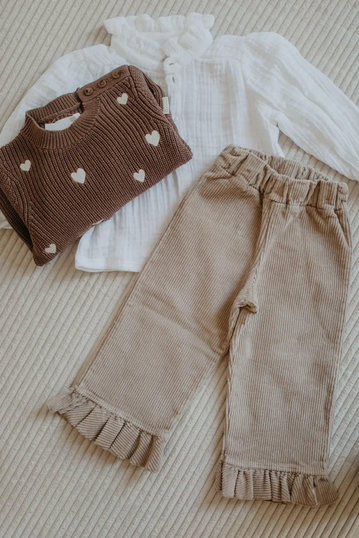 Leevje Cordhose mit Rüschen dusty rose drapiert mit dem Strickpullover Hearts in pecan und der Musselin Bluse Mini Me in white. 
