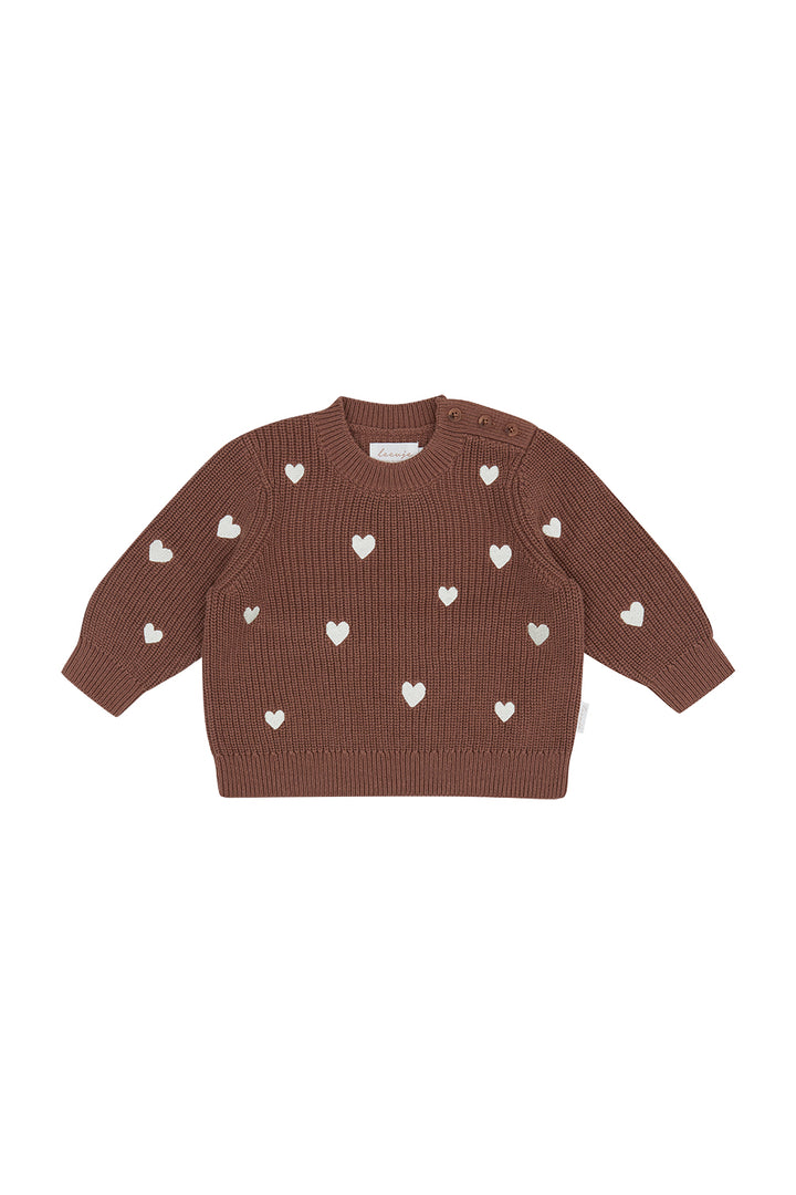 brauner Pullover aus Bio-Baumwolle für Mädchen in Patentstrick mit eingenähten cremefarbenen Herzen auf der gesamten Vorder- und Rückseite, gerippte Bündchen am Rundhalsausschnitt, Saum und an den Ärmeln. Produktbild, Ansicht von vorne. 