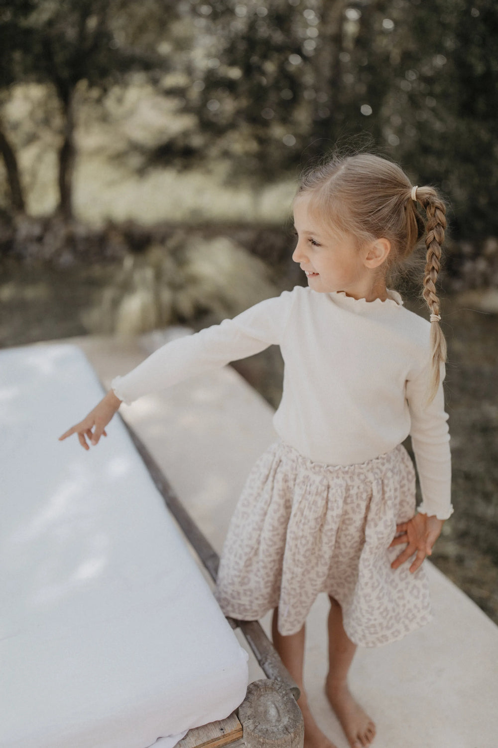 Leevje muslin skirt leo leo getragen von einem Mädchen auf einer sommerlichen Terrasse Blick von oben vorne