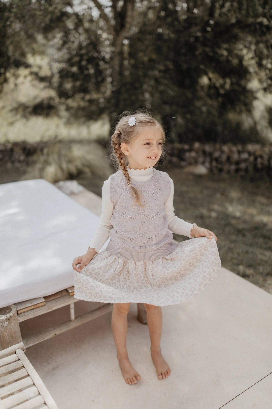 Leevje muslin skirt leo leo getragen von einem Mädchen auf einer Sommererrasse, Blick von vorne mit Fokus auf den ausgestellten Rock