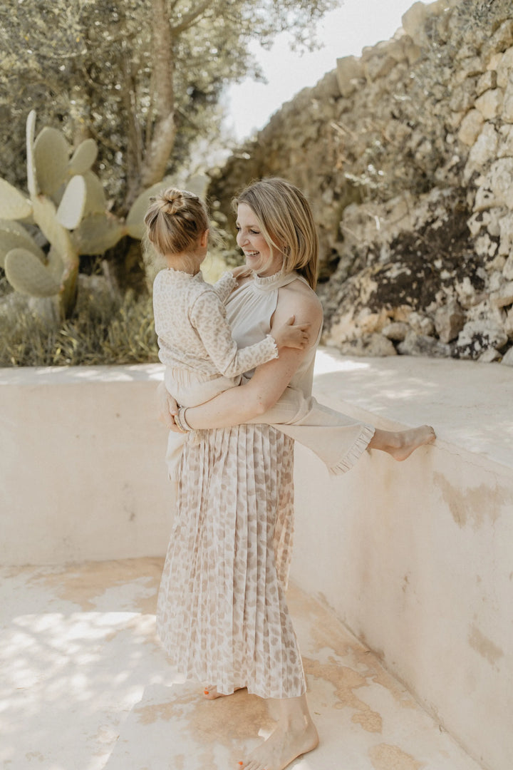 Leevje rib knit long sleeve leo getragen von einem Mädchen auf dem Arm seiner Mutter, Anblick von der Seite 