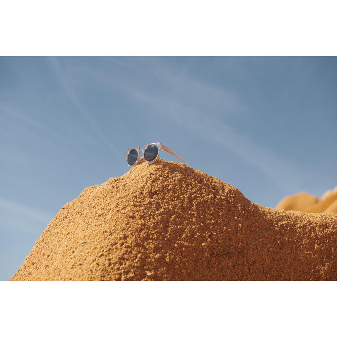 Liewood Darla Mr Bear Sunglasses rose transparent drapiert auf einem Sandberg 