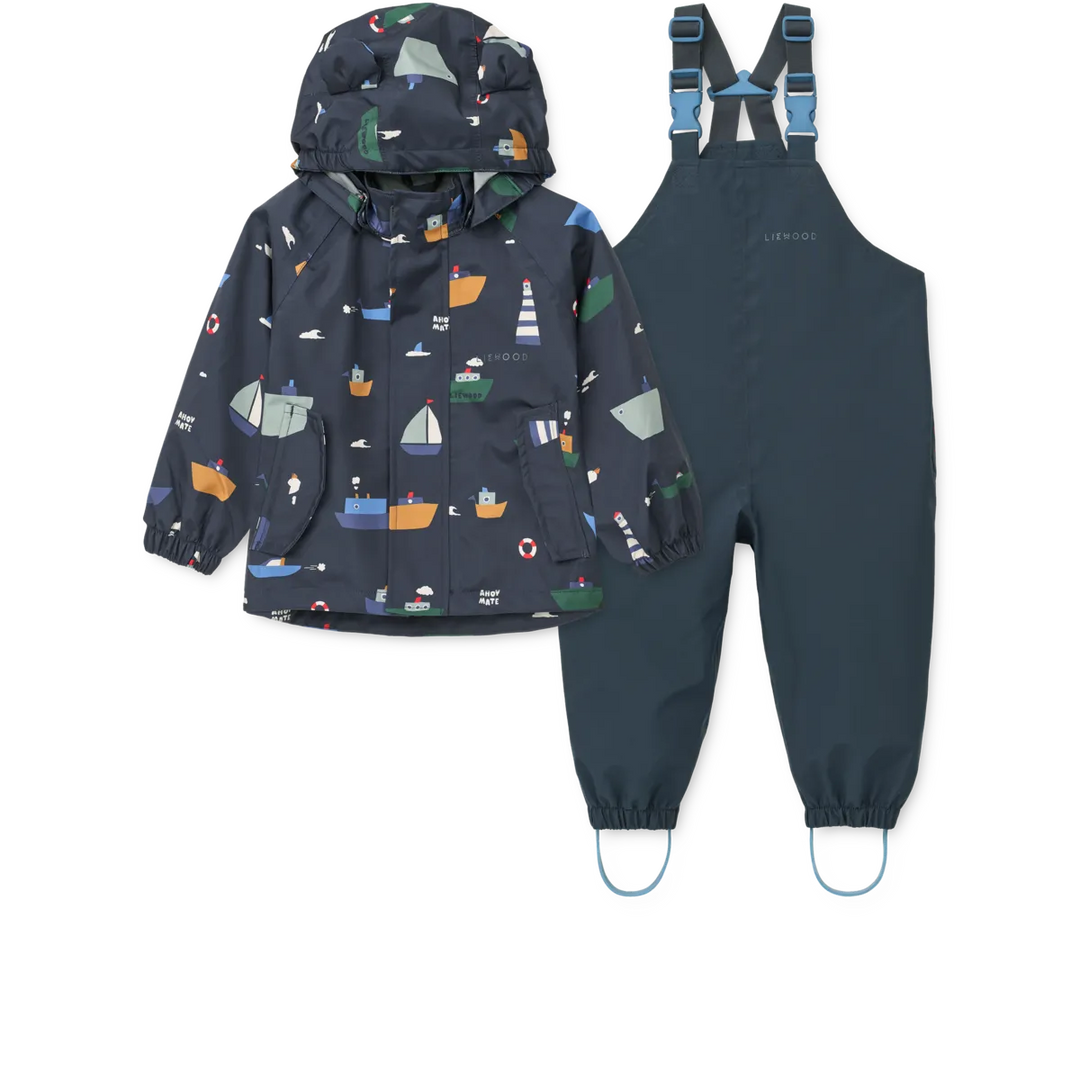 Regenbekleidungs-Set bestehend aus einer Jacke und einer Latzhose in dunkelblau für Kinder aus recyceltem Polyester mit maritimem Motiv auf der Jacke, abnehmbarer Kapuze und Reißverschluss