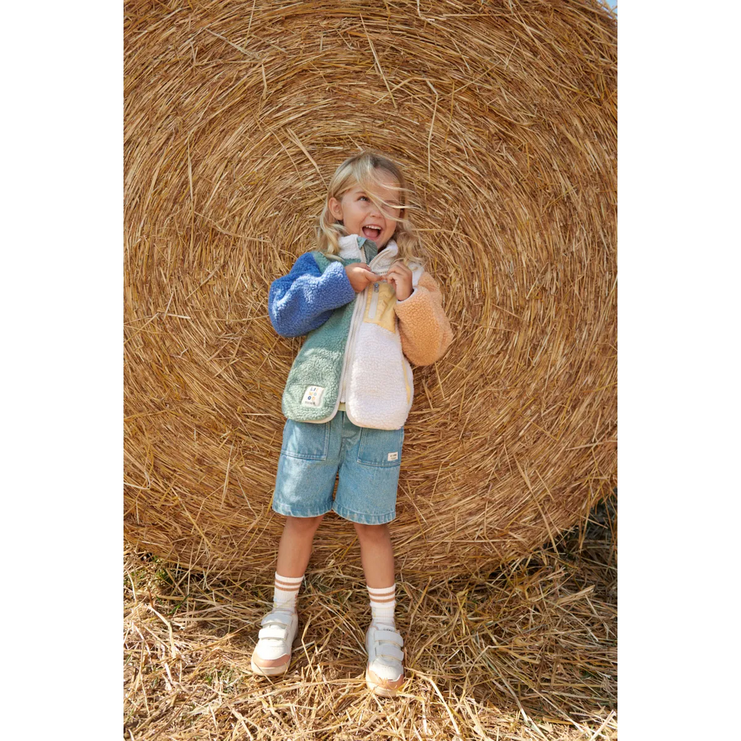 Liewood Nolan Fleecejacke peppermint multi mix getragen von einem Mädchen vor einem Heuballen stehend, Ansicht von vorne 