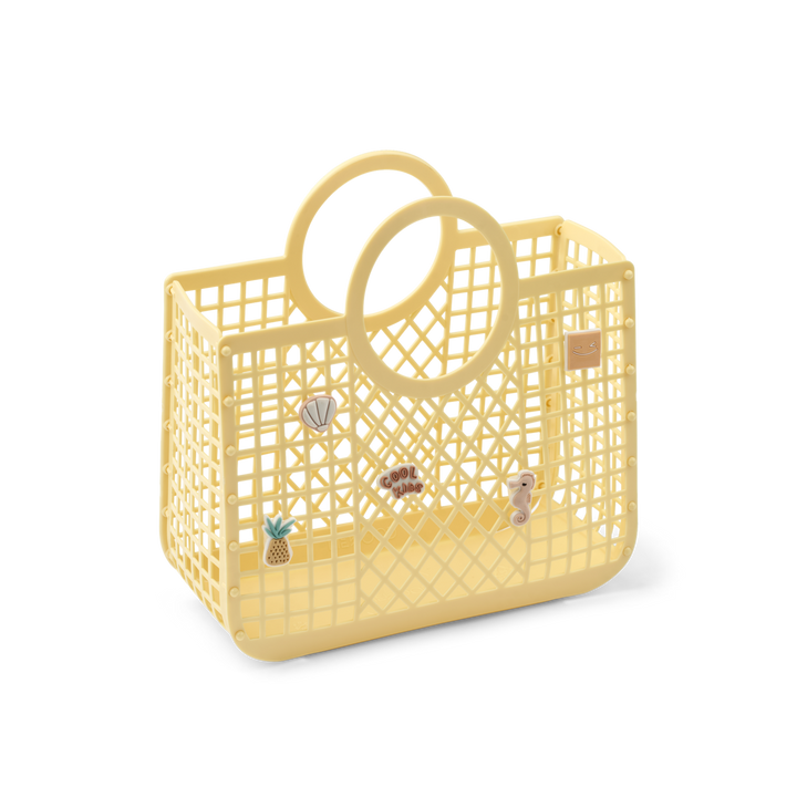 hell-gelber Korb aus gelbem Gitter aus Plastik mit kreisrunden integrierten Griffen und fünf ansteckbaren Anhängern, auseinanderklappbar. Produktbild, Ansicht von vorne
