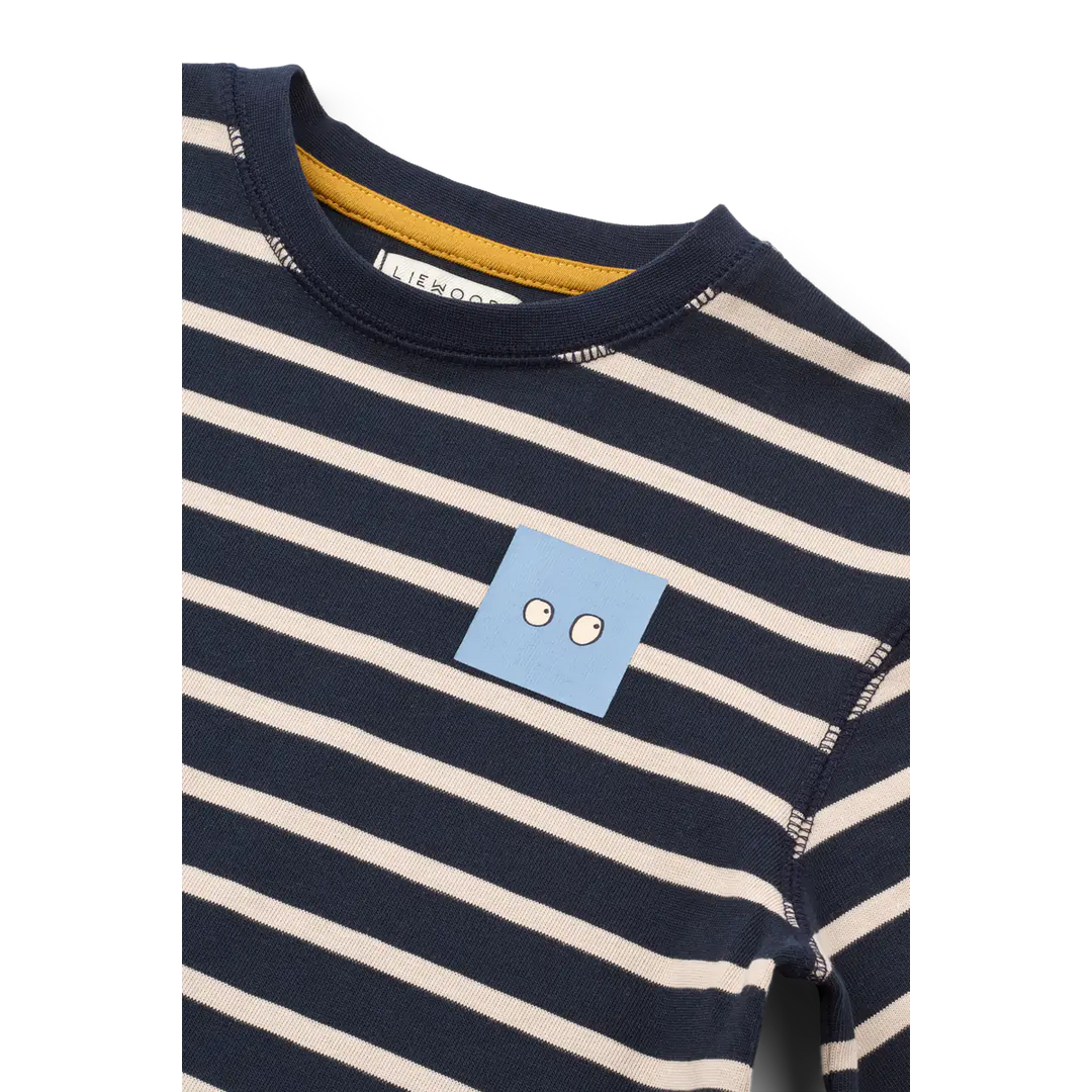 Liewood Tyler Stripe SS T-shirt Y/D stripe classic navy sandy Detailansicht hellblauer Print mit zwei Augen auf Höhe der linken Brust. 