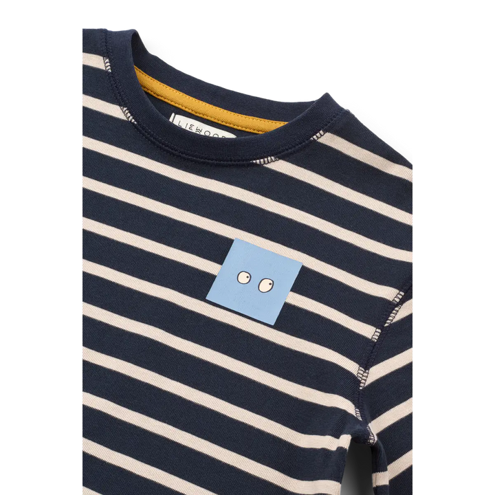 Liewood Tyler Stripe SS T-shirt Y/D stripe classic navy sandy Detailansicht hellblauer Print mit zwei Augen auf Höhe der linken Brust. 