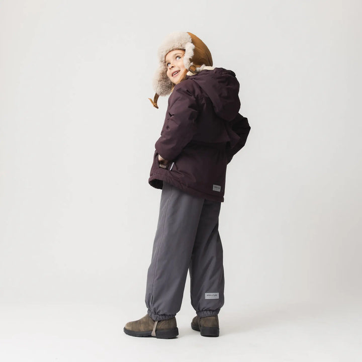 Mini A Ture Matalgeana fleece lined winter jacket GRS fudge aubergine getragen von einem Mädchen vor weißer Leinwand, Ansicht der Rückseite.