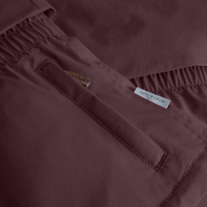 Mini A Ture Matalgeana fleece lined winter jacket GRS fudge aubergine Detailansicht seitliche Eingriffstasche, Mini A Ture - Logo und Textur des Oberstoffs. 