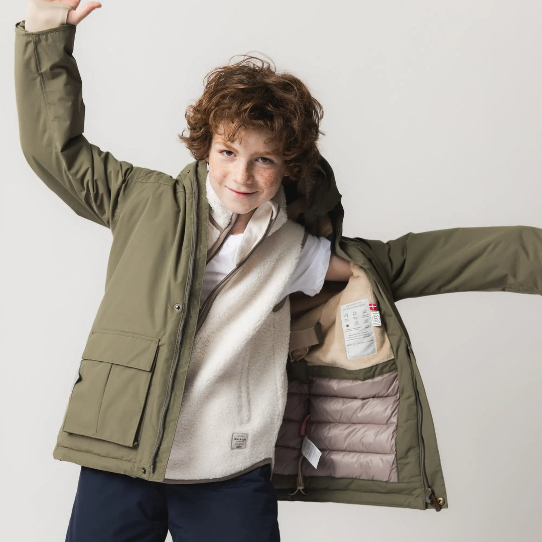 Mini A Ture Matkastorio fleece lined winter jacket GRS kalamata green getragen von einem Jungen mit geöffnetem Reißverschluss, Ansicht von vorne. 