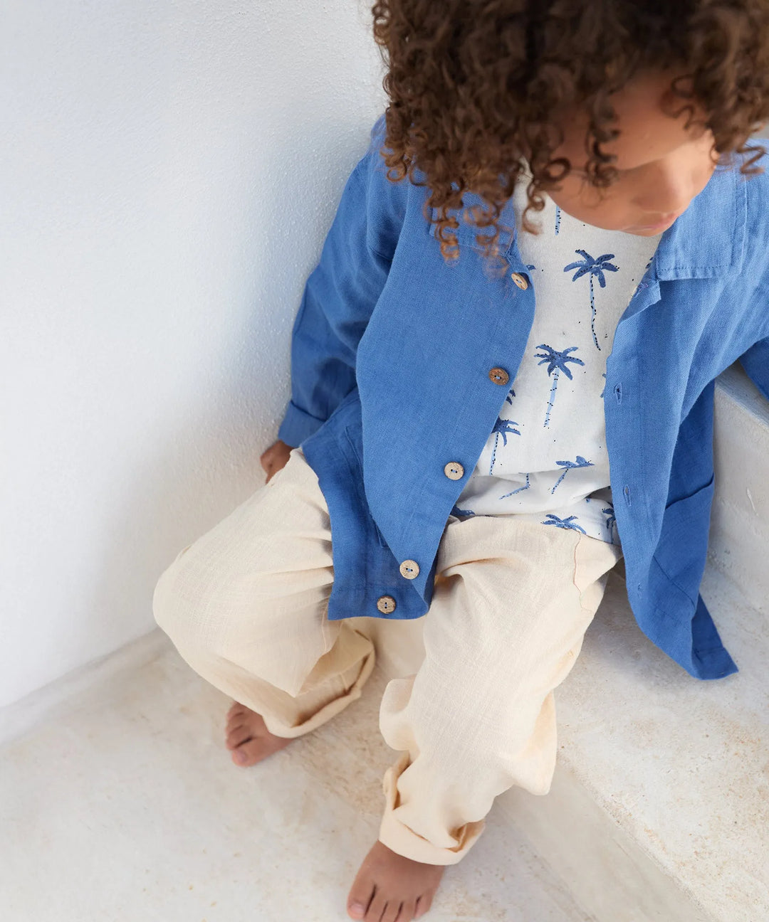 Play Up Printed Jersey T-Shirt bio resin getragen von einem Jungen, der auf einer Treppe sitzt, kombiniert mit einem mittelblauen Hemd, Blick von oben