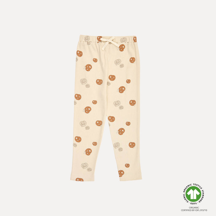 cremefarbene Hose mit geradem Bein für Babys und Kinder mit Brezel-Allover-Print. gerippte Jersey-Struktur. Gummibund mit Kordelzug. Produktbild, Ansicht von vorne. 