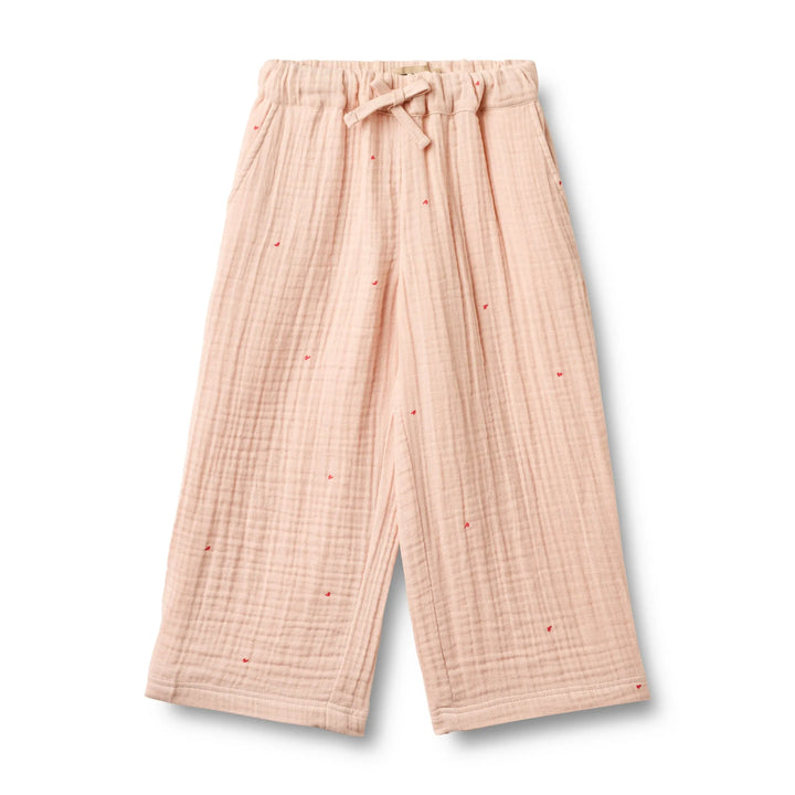 pfirsich-rosafarbene Hose für Mädchen aus Musselin aus Bio-Baumwolle mit weitem Bein, Gummibund, seitlichen Eingriffstaschen und aufgedruckten kleinen roten Herzen mit größerem Abstand zueinander