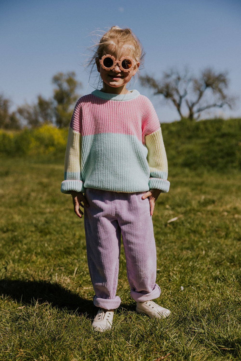 Yuki Color Block Sweater STICKY CANDY getragen von einem Mädchen stehend auf einer grünen Wiese Ganzkörperaufnahme Ansicht von vorne