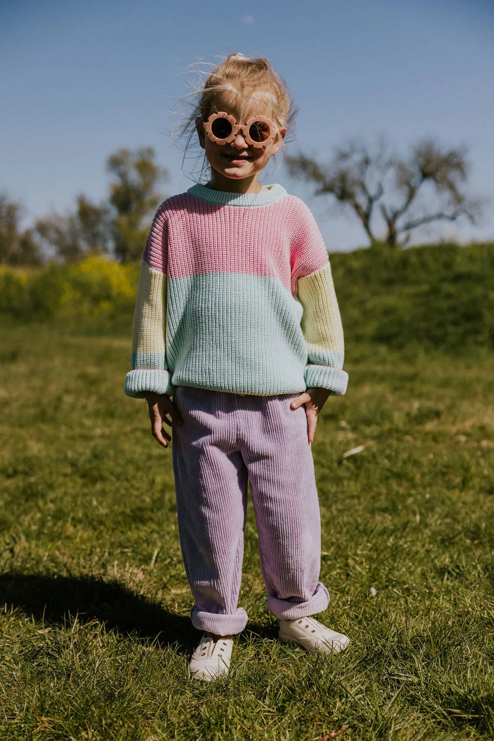 Yuki Color Block Sweater STICKY CANDY getragen von einem Mädchen stehend auf einer grünen Wiese Ganzkörperaufnahme Ansicht von vorne