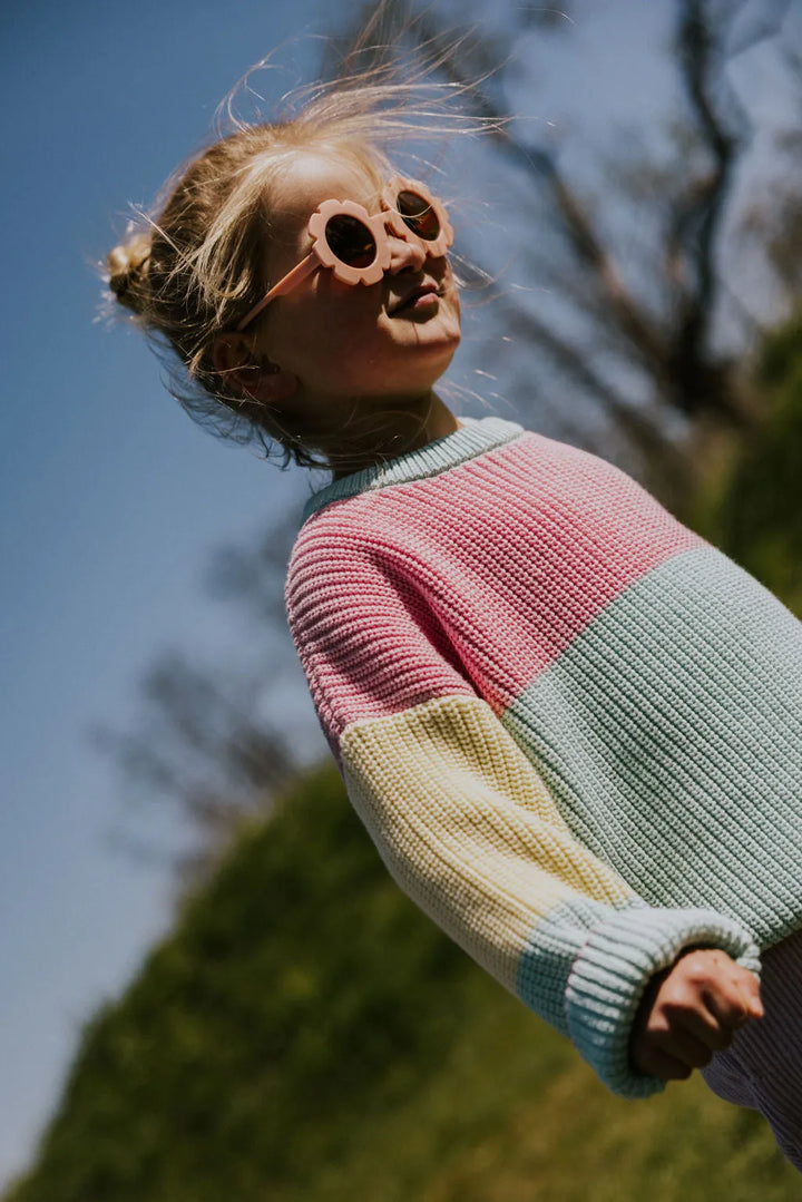 Yuki Color Block Sweater STICKY CANDY getragen von einem Mädchen stehend auf einer grünen Wiese Nahaufnahme Oberkörper Ansicht von der Seite 